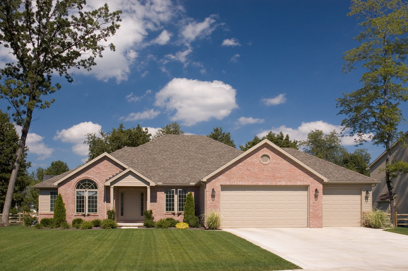 ranch style brick home with 3 car garage and manicured lawn