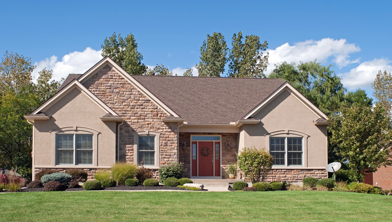 a lovely brink one story home with a green lawn